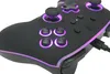 A close-up shot of a black gaming controller with purple LED lighting. Voir les images du produit