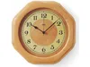 A wooden octagonal wall clock with a beige face and black numbers and hands. Anteprima dell’immagine prodotto