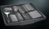 A dishwasher cutlery basket filled with silverware and a spatula. Produktbild-Vorschau