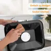 A person is cleaning the top of a black appliance with a brown cloth. Voir les images du produit