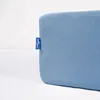 A close-up of a blue fitted sheet with a small blue tag on the left side. Náhľad obrázku produktu