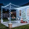 A decorated patio at night with Christmas lights, a Christmas tree, and Santa Claus. Produktbild-Vorschau