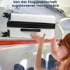 A woman is placing a white suitcase into the overhead compartment of an airplane. Náhled obrázku produktu