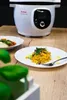 A Tefal Cook4me+ smart multi-cooker is shown in the background, with two plates of food in the foreground, suggesting a meal prepared with the appliance. Podgląd zdjęcia produktu