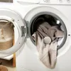 A close-up of a washing machine with laundry inside and the door open. Produktbild-Vorschau