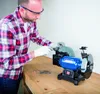 A man is using a wet and dry grinder to sharpen scissors. Náhľad obrázku produktu