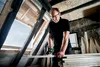 A man is working on wood in an attic. Podgląd zdjęcia produktu