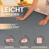 A person's hands are shown on a grey fabric, likely a bedsheet, with marketing text and icons overlaid. Produktbild-Vorschau
