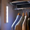 A battery-powered LED light strip illuminates a closet with hanging clothes. Produktbild-Vorschau