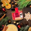 A festive Christmas scene with a jar of Eierlikör, gingerbread cookies, pine branches, and spices. Produktbild-Vorschau
