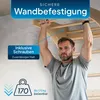 A man is hanging from a wooden climbing frame attached to a wall, demonstrating its secure mounting. Podgląd zdjęcia produktu