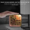 A hand touching the top of an alarm clock, with text overlay describing its features. Produktbild-Vorschau