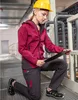 A woman in workwear kneels on a metal grate floor, holding a clipboard. Anteprima dell’immagine prodotto