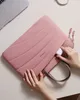 A person is putting a white wireless earbud case into a pink laptop bag. Produktbild-Vorschau