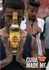A man holds up a bottle of Havana Club rum in front of other people. Produktbild-Vorschau