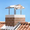 A chimney cap on top of a brick chimney on a tiled roof, against a clear blue sky. Voir les images du produit