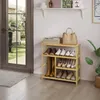 A bamboo shoe rack filled with shoes and a handbag is placed near a doorway with a view of a garden. Produktbild-Vorschau