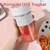 A hand holds a portable smoothie blender filled with a pink smoothie, with a plate of food in the background. Produktbild-Vorschau
