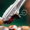 A close-up shot of metal skewers holding pieces of food, likely for grilling. Produktbild-Vorschau