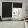 A kitchen scene with a window covered by black roller blinds. Voir les images du produit