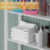 A shelf with folded white towels and toiletries. Produktbild-Vorschau