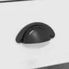 A close-up view of a black drawer pull on a white surface. Podgląd zdjęcia produktu