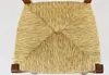 A close-up view of the woven straw seat of a chair, with dark wooden legs visible at the bottom corners. Produktbild-Vorschau
