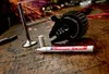 A paint marker and engine parts are on a wooden workbench with sparks flying in the background. Produktbild-Vorschau