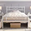 A white metal bed frame with a mattress and bedding in a bedroom setting. Produktbild-Vorschau