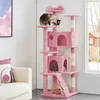 A pink cat tree with multiple levels and platforms, featuring three cats interacting with it. The background is a room with a window and a sofa. Produktbild-Vorschau