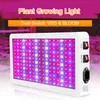 A white LED plant grow light with red and blue LEDs, featuring two switches labeled 'VEG' and 'BLOOM'. The background is blurred and shows hints of plants and pink/purple lighting. Náhľad obrázku produktu