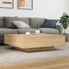 A modern living room scene with a grey sofa and a light wood coffee table. Podgląd zdjęcia produktu