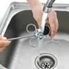 A person is rinsing a meat injector under a faucet in a kitchen sink. Voir les images du produit