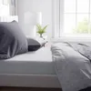 A close-up view of a bed with gray bedding, including a fitted sheet and pillows, next to a window. Anteprima dell’immagine prodotto