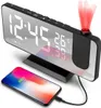 A digital alarm clock with a projection feature and a smartphone charging on its base. Produktbild-Vorschau