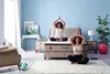 Two women are meditating on a bed and on the floor in a bedroom. Produktbild-Vorschau