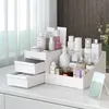 A white cosmetic organizer filled with various skincare and beauty products on a white surface with a window and curtain in the background. Náhľad obrázku produktu