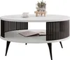 A white round coffee table with black slatted sides and a lower shelf, featuring a cup and saucer and a plant in a glass vase on top. Produktbild-Vorschau