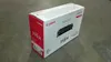 A Canon toner cartridge box is placed on a concrete floor. Náhľad obrázku produktu