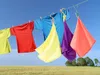 Laundry drying on a clothesline against a blue sky and a grassy field. Anteprima dell’immagine prodotto