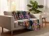 A cozy living room scene with a blanket draped over a sofa. Podgląd zdjęcia produktu