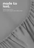 A close-up of a gray fitted sheet with text overlay. Produktbild-Vorschau
