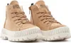 A pair of tan Palladium boots with white soles and laces, shown from a slightly elevated side angle against a white background.