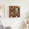 A wooden display shelf mounted on a white wall, filled with various decorative items and boxes. A framed picture is on the left, and a chair and a side table with a vase are visible on the right. Náhled obrázku produktu