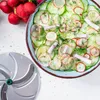 A salad made of sliced cucumbers and radishes with dill, next to a food processor blade. Anteprima dell’immagine prodotto