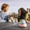 A couple sitting at a table outdoors, with a stress ball in the foreground. Voir les images du produit
