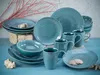 A collection of blue ceramic tableware, including plates, bowls, and mugs, arranged on a blue surface with decorative coral branches and shells. Náhľad obrázku produktu