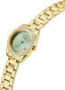 A close-up, angled shot of a gold-colored women's watch with a light green face and crystal accents around the bezel. Náhľad obrázku produktu