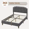 A dark gray upholstered bed frame with a tufted headboard and wooden slats is shown from a diagonal angle. Text overlays highlight the product's stability and weight capacity. Produktbild-Vorschau
