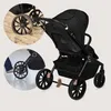 A black stroller with inset images showing its wheels on sand and being used. Voir les images du produit